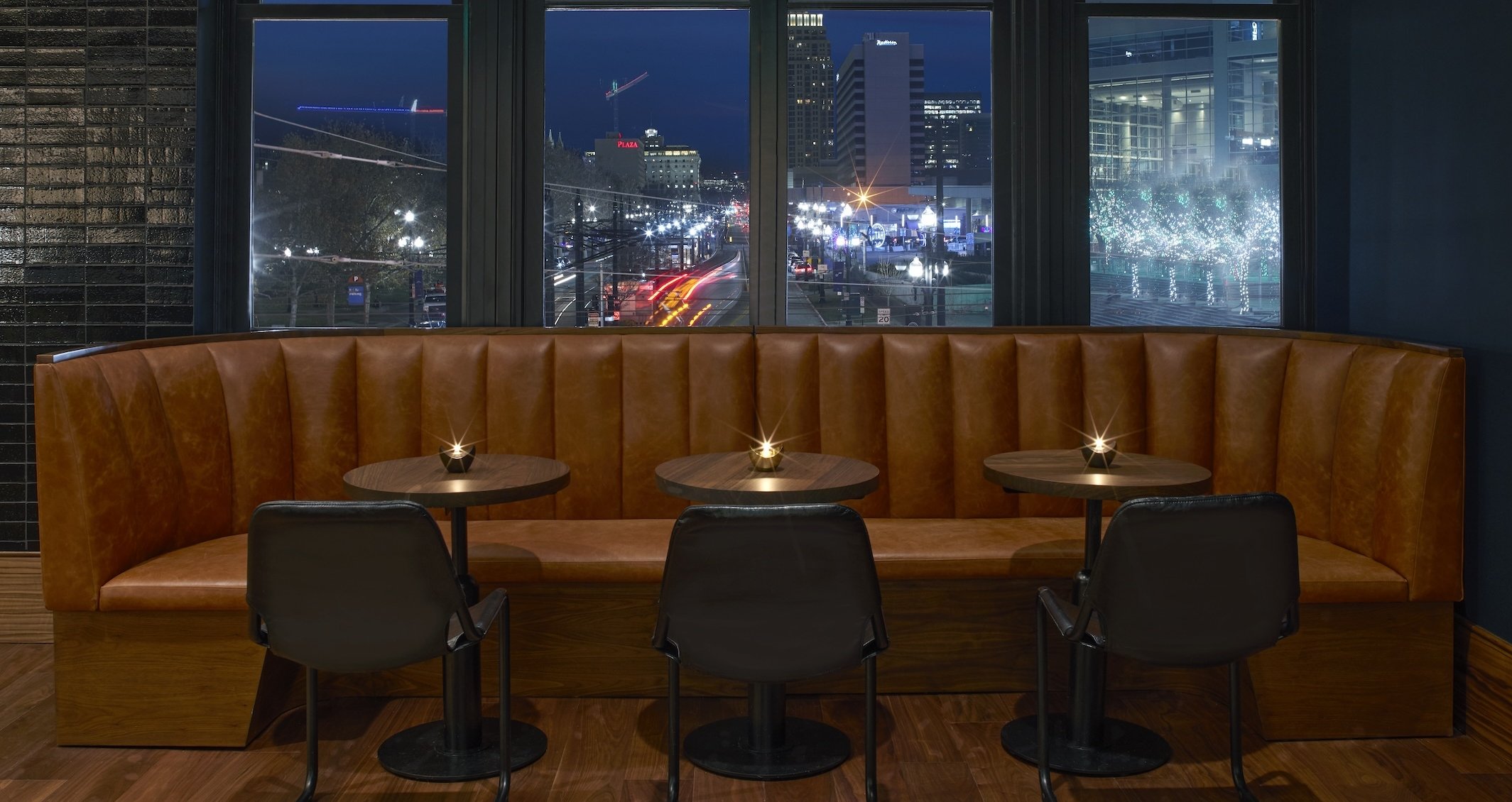 A booth inside No. 119 with views of downtown Salt Lake City lit up at night
