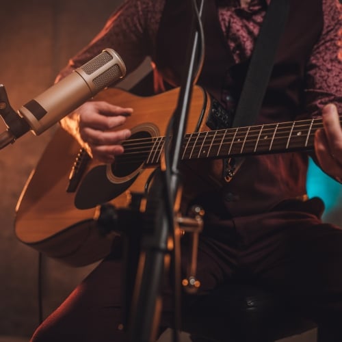 A performer plays guitar in a bar.