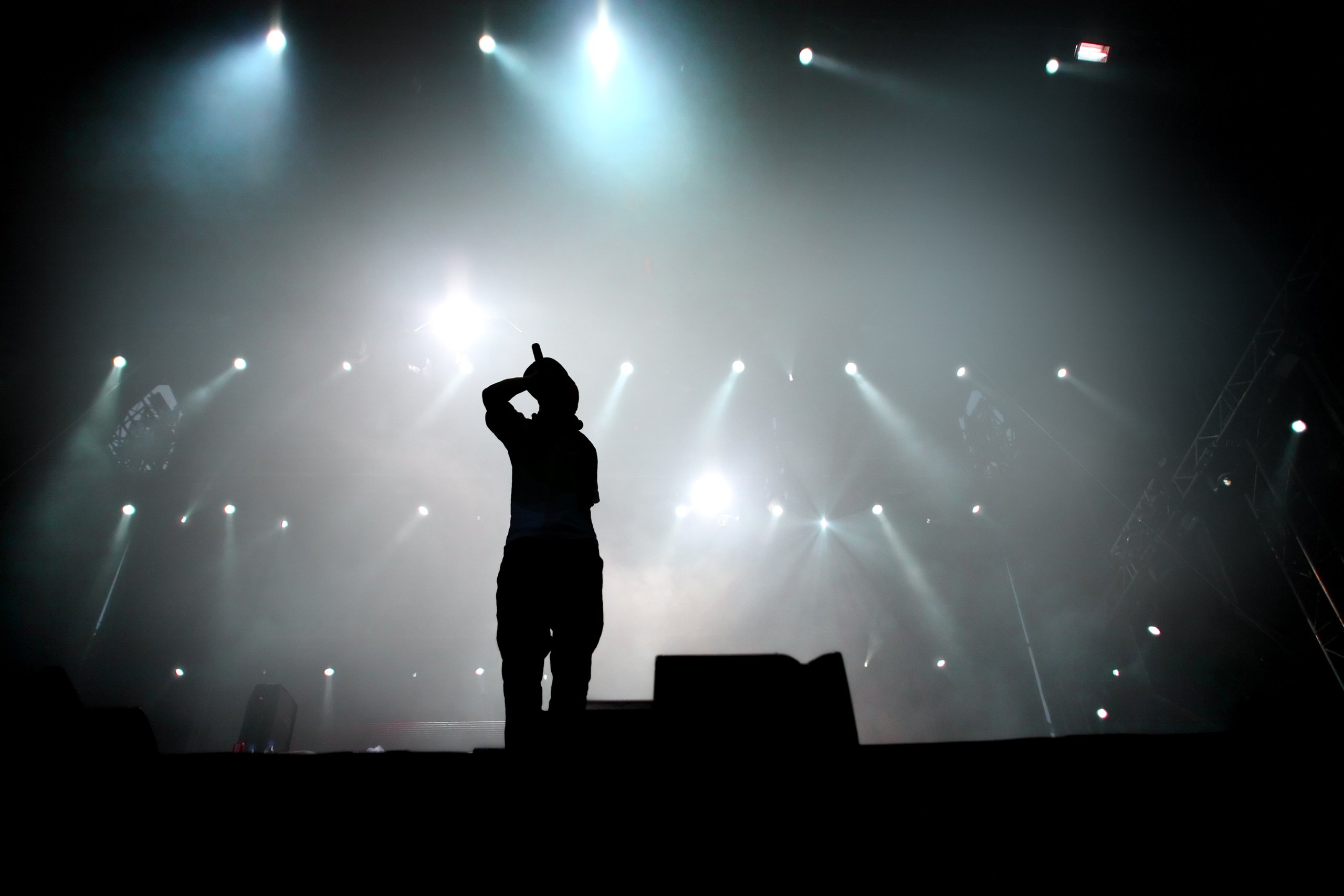 The silhouette of a singer performing on a large stage.