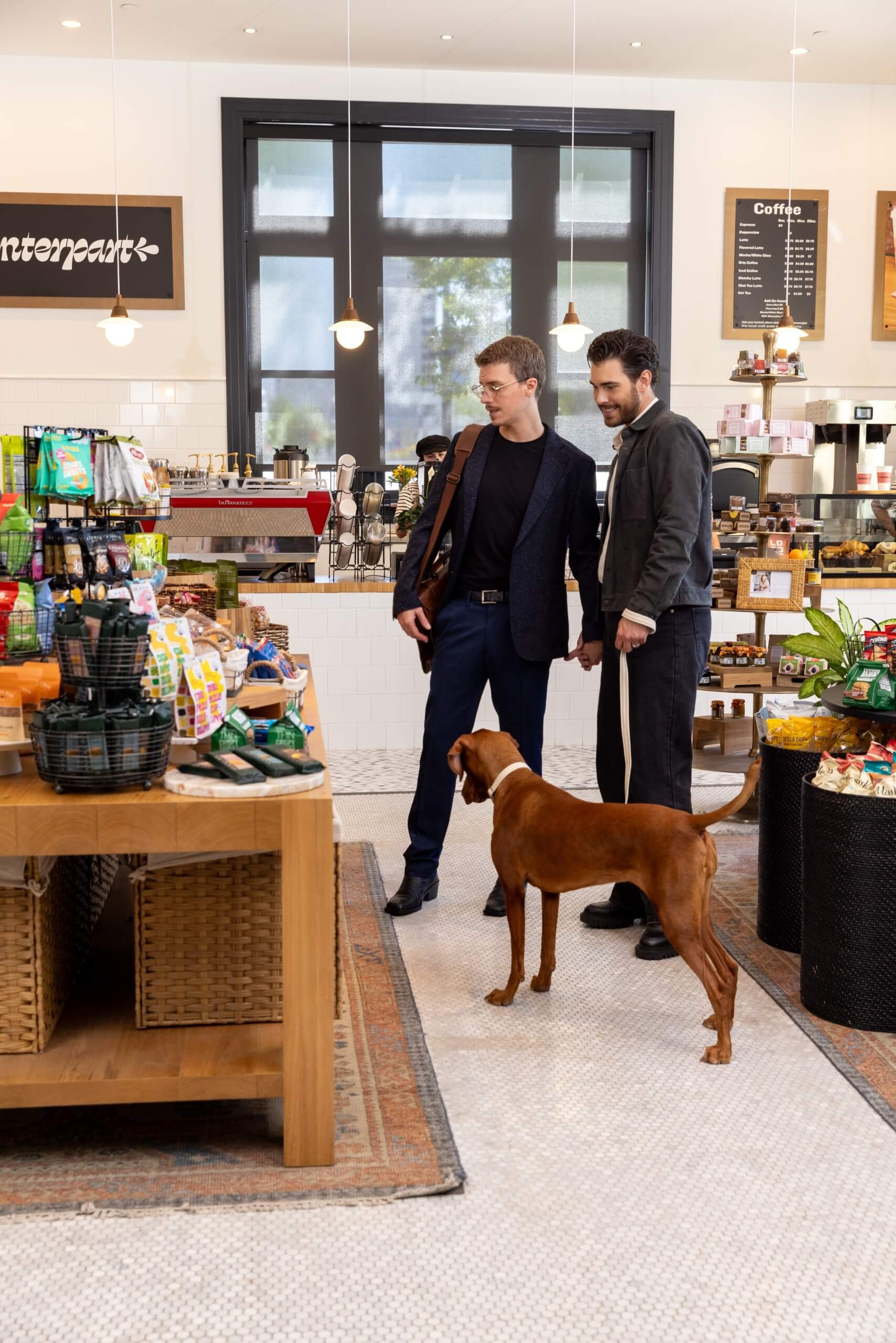 Two men in suits shopping with a dog at Counterpart