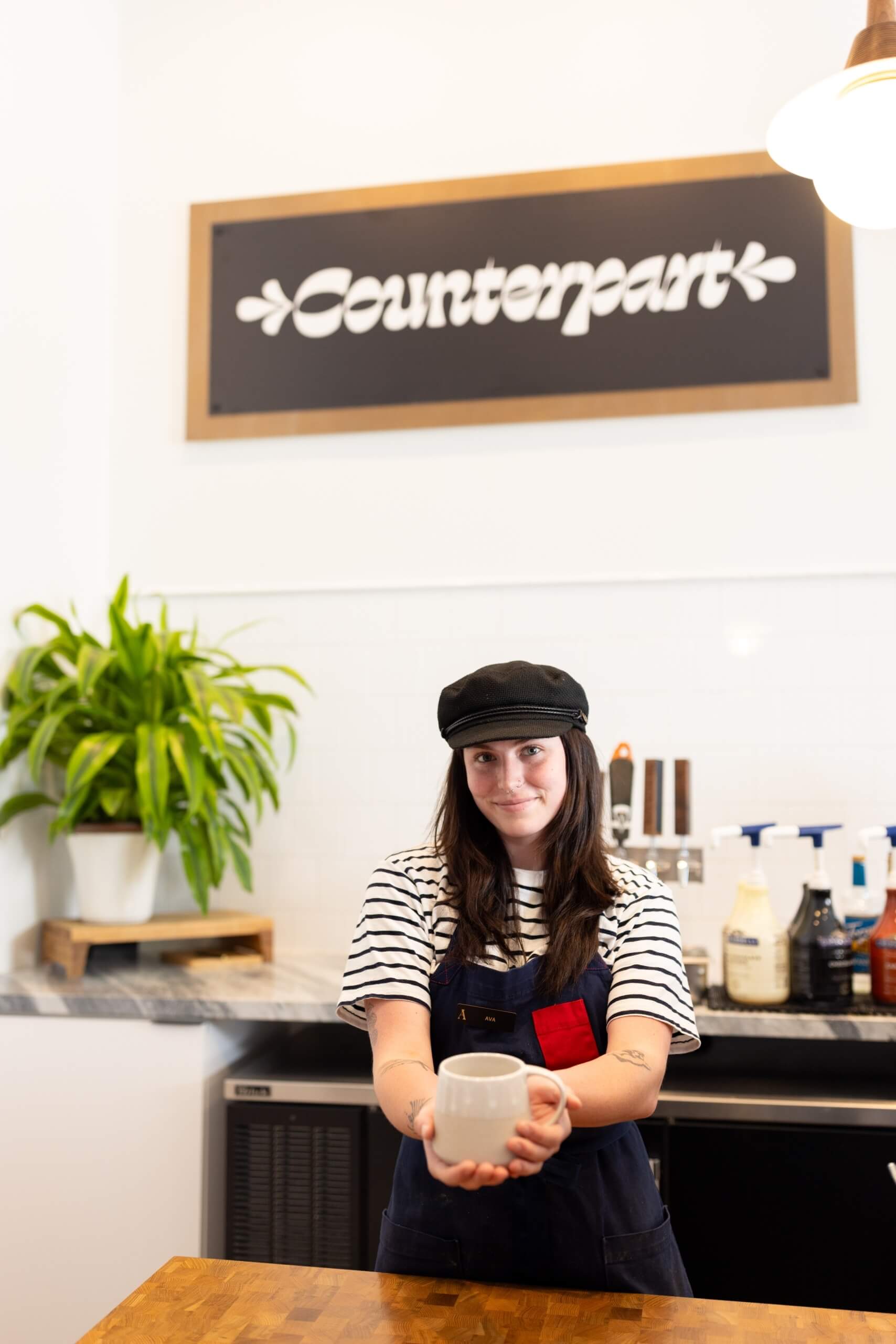 A barista at Counterpart with a modern white design
